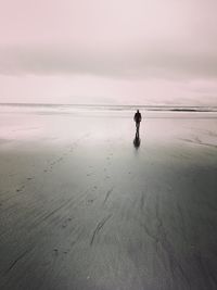 Man standing on beach against sky