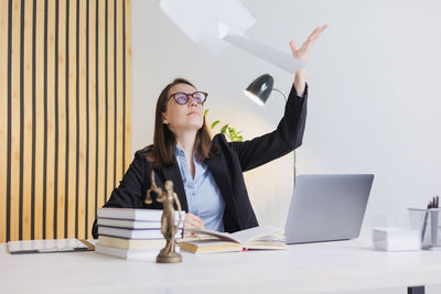 Businesswoman using laptop while sitting on table