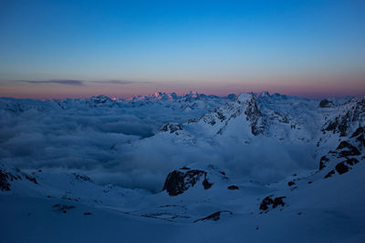 Scenic view of snow covered mountains against clear sky