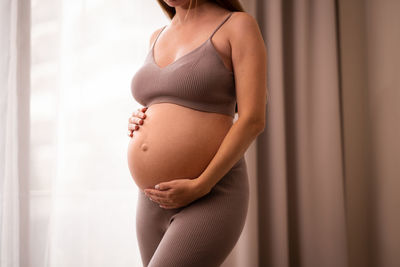 Midsection of woman standing at home