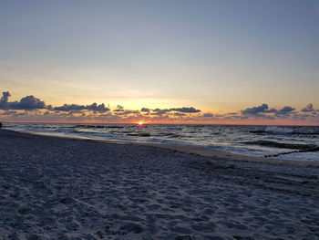 Scenic view of beach against clear sky during sunset