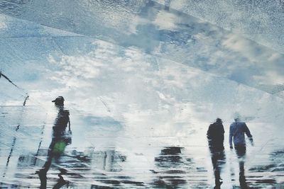 Reflection of people walking on wet street