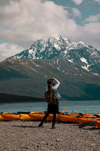Man with umbrella on snowcapped mountain against sky
