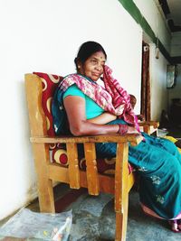 Portrait of woman sitting on chair at home