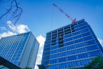 Low angle view of modern buildings against blue sky