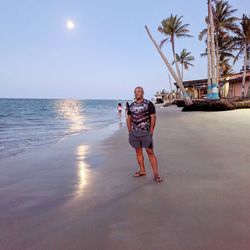 Full length portrait of man on beach against sky