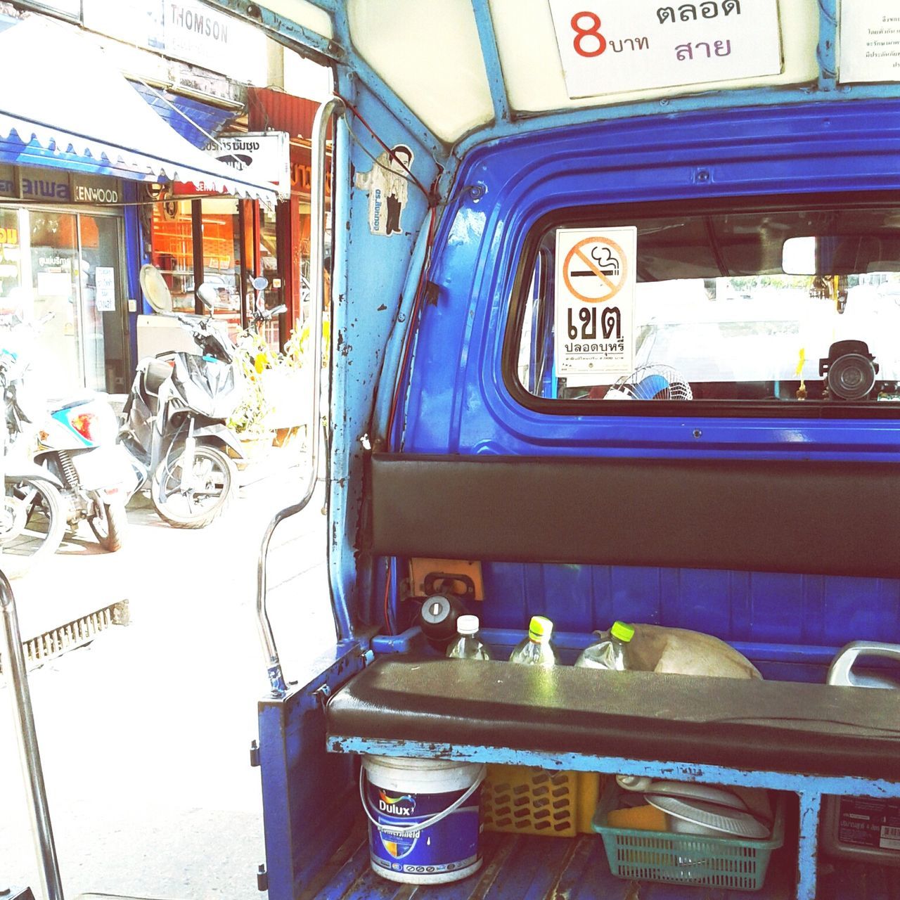 window, mode of transport, transportation, architecture, built structure, indoors, day, land vehicle, building exterior, no people, blue, car, reflection, house, text, table, chair, balcony, absence