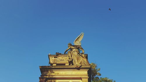 Low angle view of statue against clear blue sky