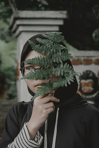 Portrait of woman holding leaf