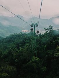 Low angle view of overhead cable car against sky