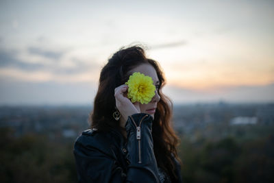 Portrait of woman holding umbrella against sky during sunset