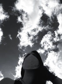 Low angle portrait of woman standing against sky