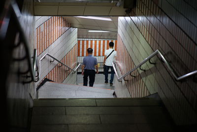 Rear view of men on staircase in subway