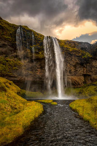 Scenic view of waterfall against sky