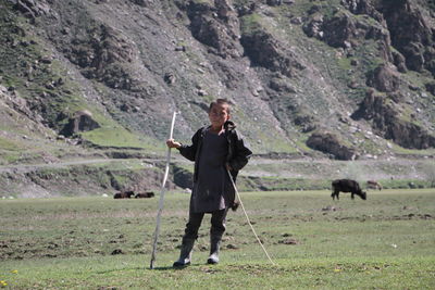 Rear view of afghan boy herding sheeps