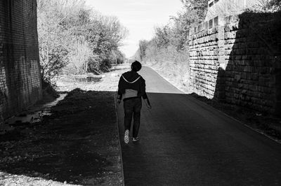 Rear view of man walking on street in city