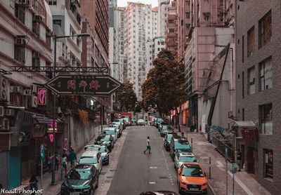 Cars on road amidst buildings in city