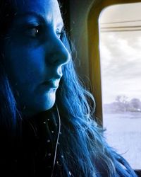 Close-up of woman looking through window