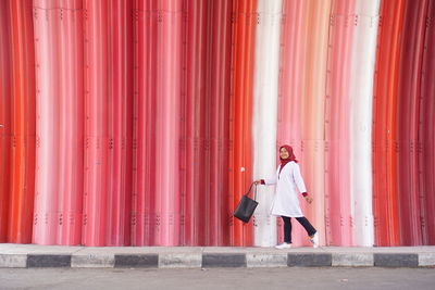 Woman standing against red wall