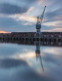 Reflection of building in river during sunset