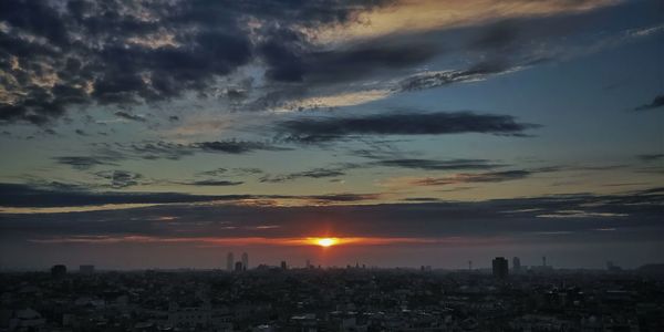 Aerial view of cityscape against sky during sunset