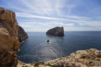 Rock formations in sea against sky