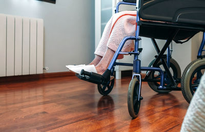 Low section of man sitting on hardwood floor at home