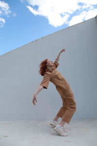 Low angle view of woman standing on wall