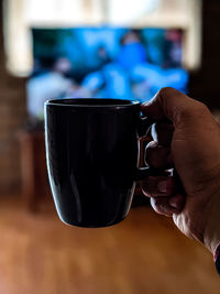 Close-up of hand holding coffee cup