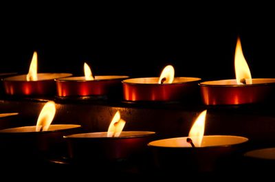 Close-up of lit candles in the dark