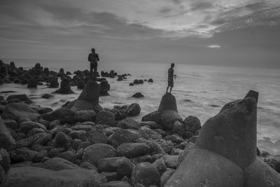 Stack of stones on beach against sky