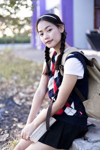 Portrait of a smiling young woman sitting outdoors