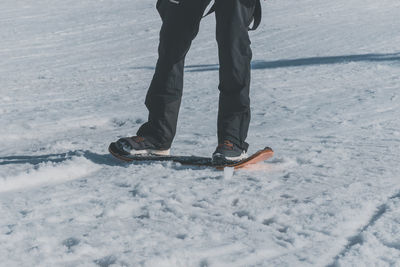 A close-up shot of a caucasian man sliding down a slope on a snow skate at a ski resort in france