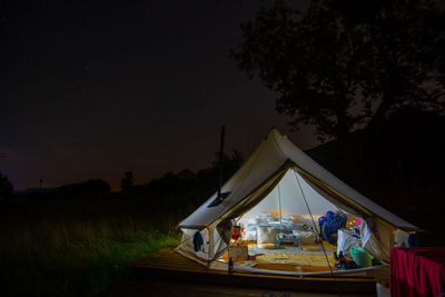 Tent on field against clear sky at night