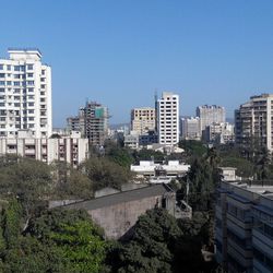 Buildings in city against blue sky