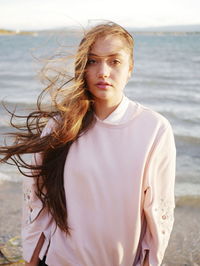Portrait of beautiful young woman standing at beach