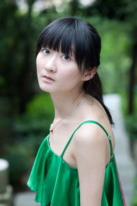 Portrait of young woman wearing green sleeveless top