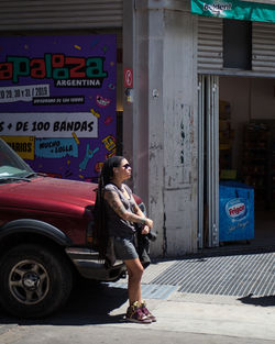 Full length of woman with text on footpath in city