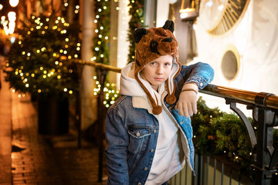 Young guy posing by the christmas tree on the street