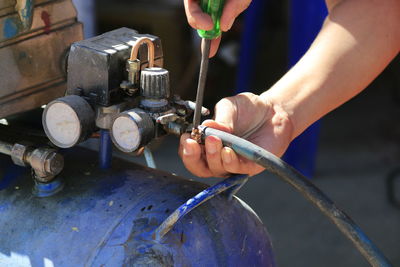 Cropped hands of worker adjusting equipment in workshop