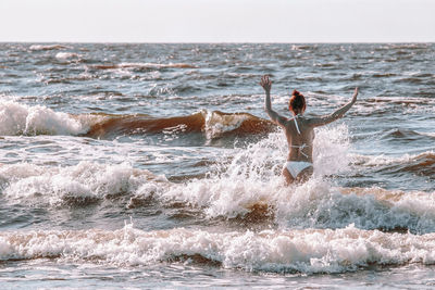 Woman surfing in sea