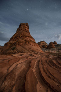 Scenic view of rock formations against sky at night