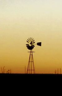 Wind turbines on landscape at sunset