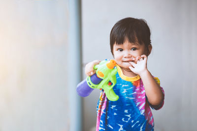 Portrait of cute baby girl holding squirt gun