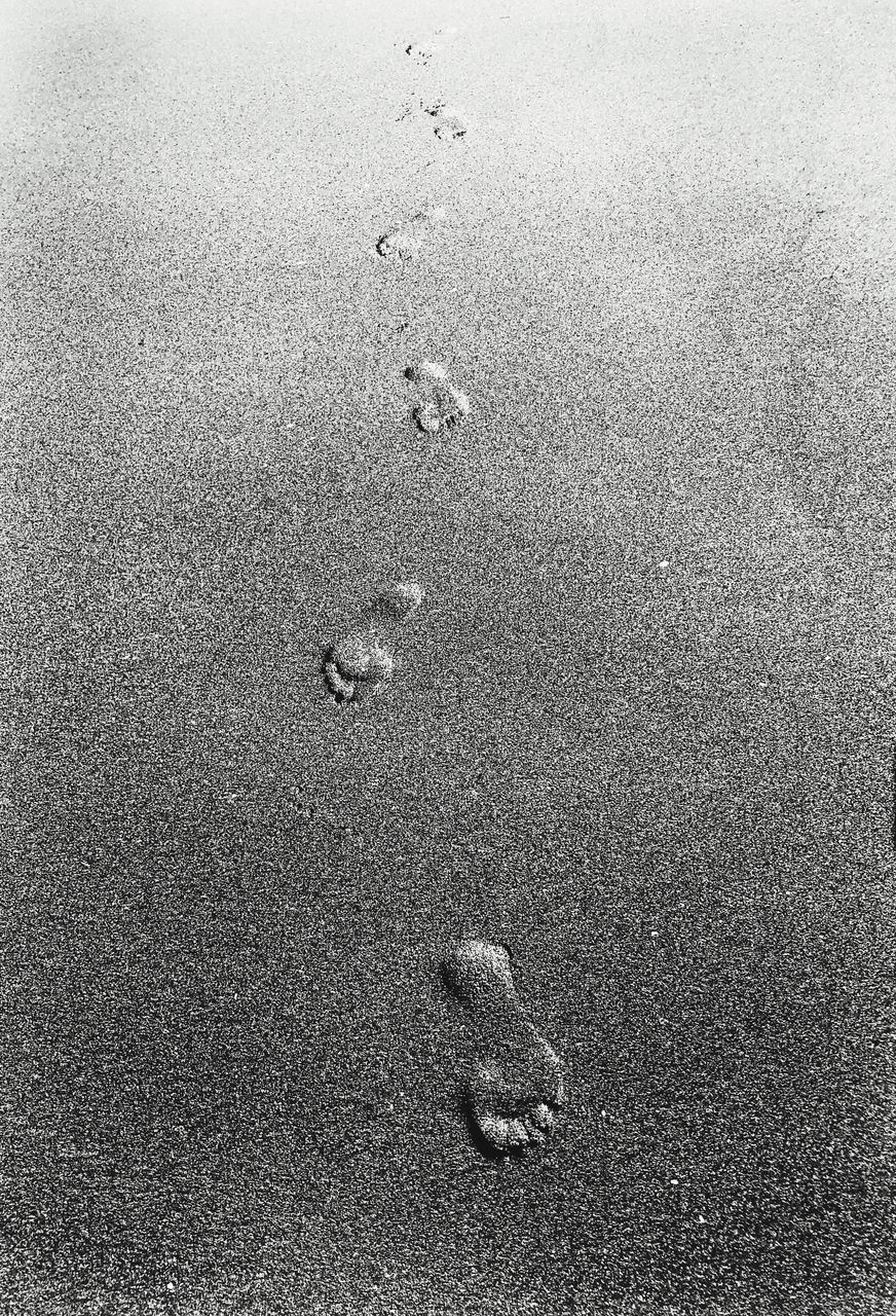 HIGH ANGLE VIEW OF FOOTPRINTS ON BEACH