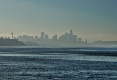 Scenic view of sea by buildings against clear sky