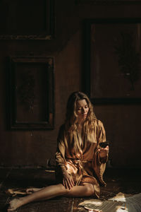 Young attractive female sitting with butterfly on her hand