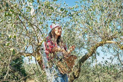 Young woman smiling while standing by plants