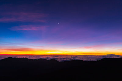 Scenic view of silhouette mountains against sky at sunset