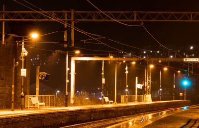 Illuminated railroad station platform at night